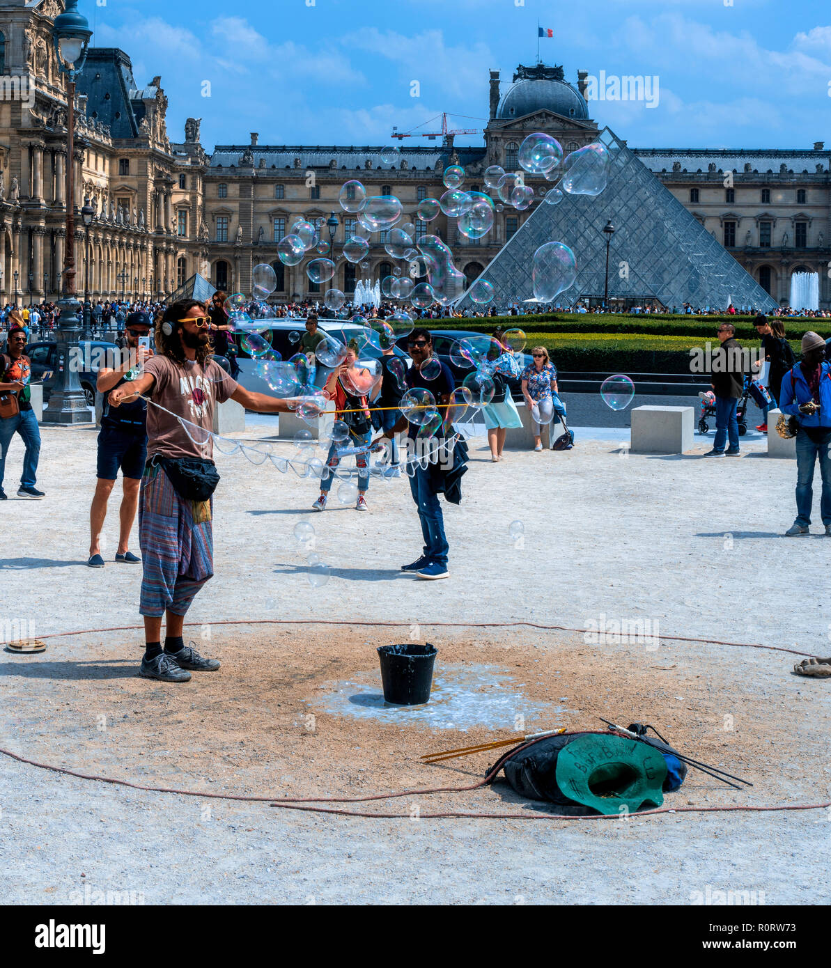 Un jeune homme à la hanche fait de grosses bulles près du Louvre dans les jardins des Tuileries, Paris, France Banque D'Images
