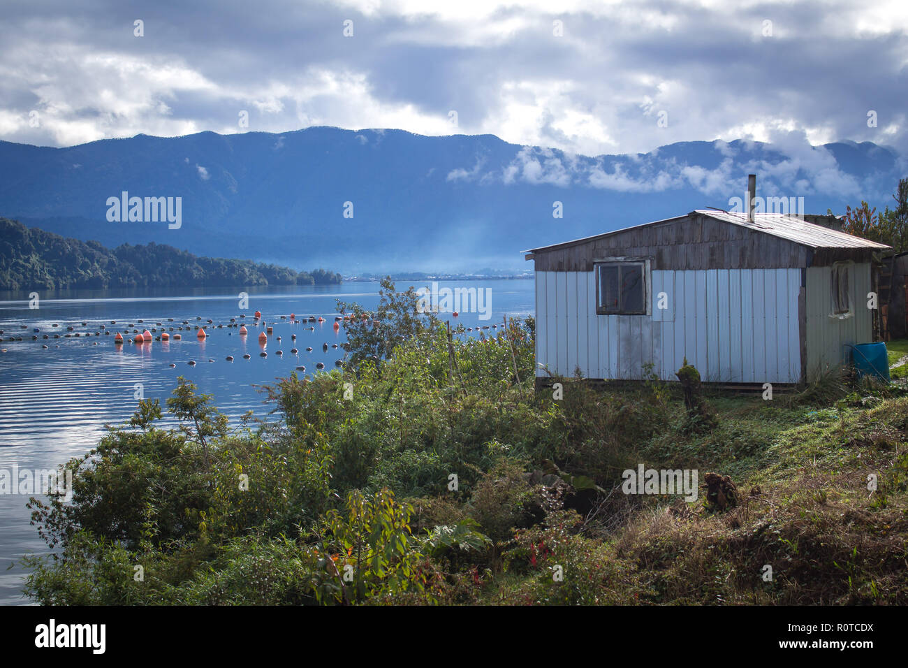 Petit chalet en bois à côté de l'océan Pacifique et du fjord près de ferme marine à Route Austral, d'Aysen, au Chili, en Patagonie Banque D'Images