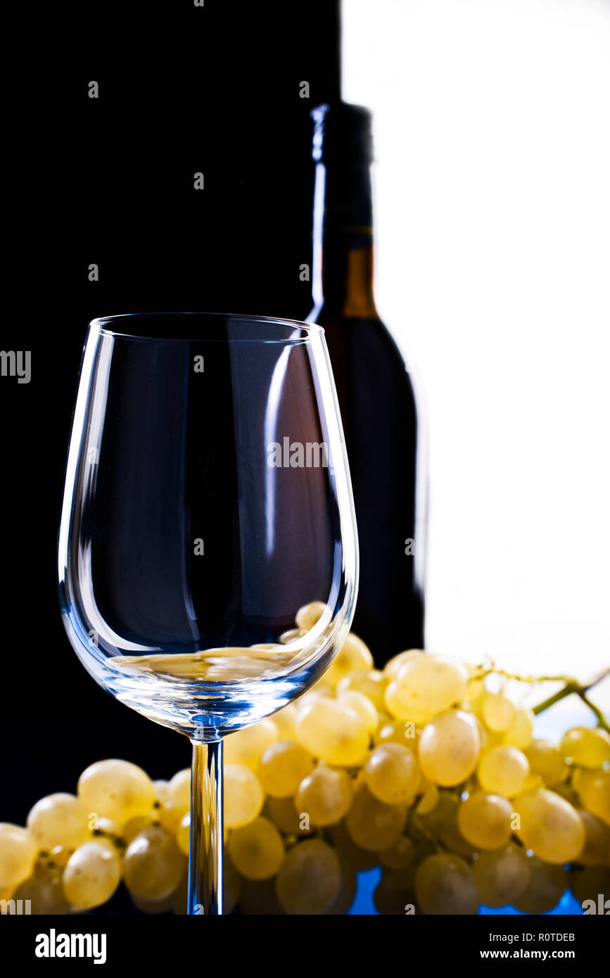 Les raisins de la lumière près d'un verre de vin sur un fond contrastant noir et verre de belogovino Banque D'Images