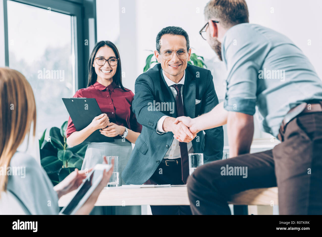 Partenaires d'affaires shaking hands in office moderne après conversation Banque D'Images