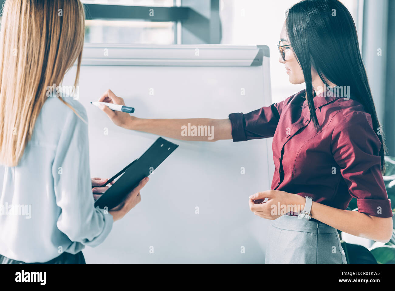 Dans femmes d'usure formelle écrit sur le tableau blanc Banque D'Images