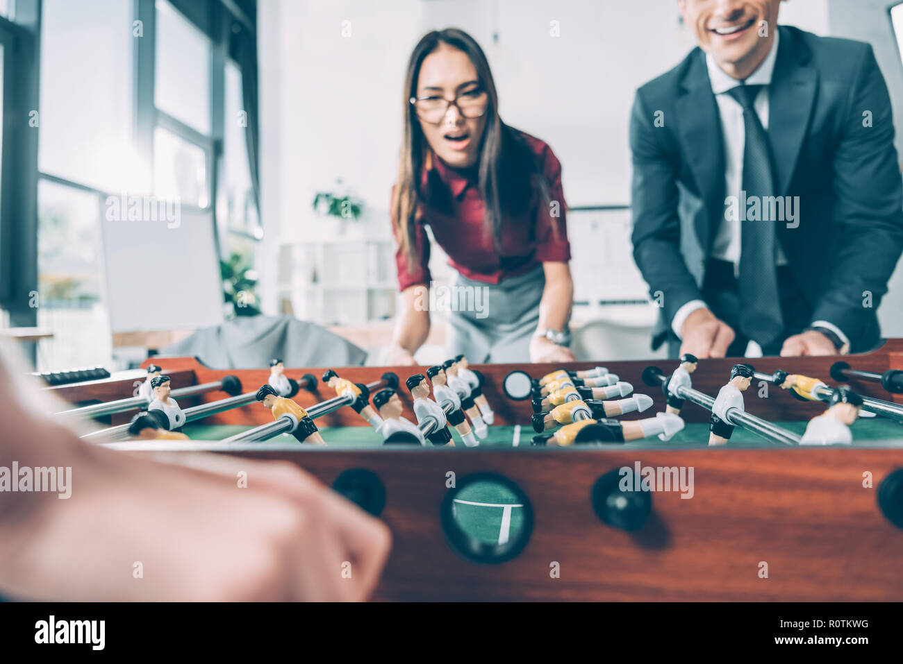 Close-up shot of woman playing table football in modern office Banque D'Images