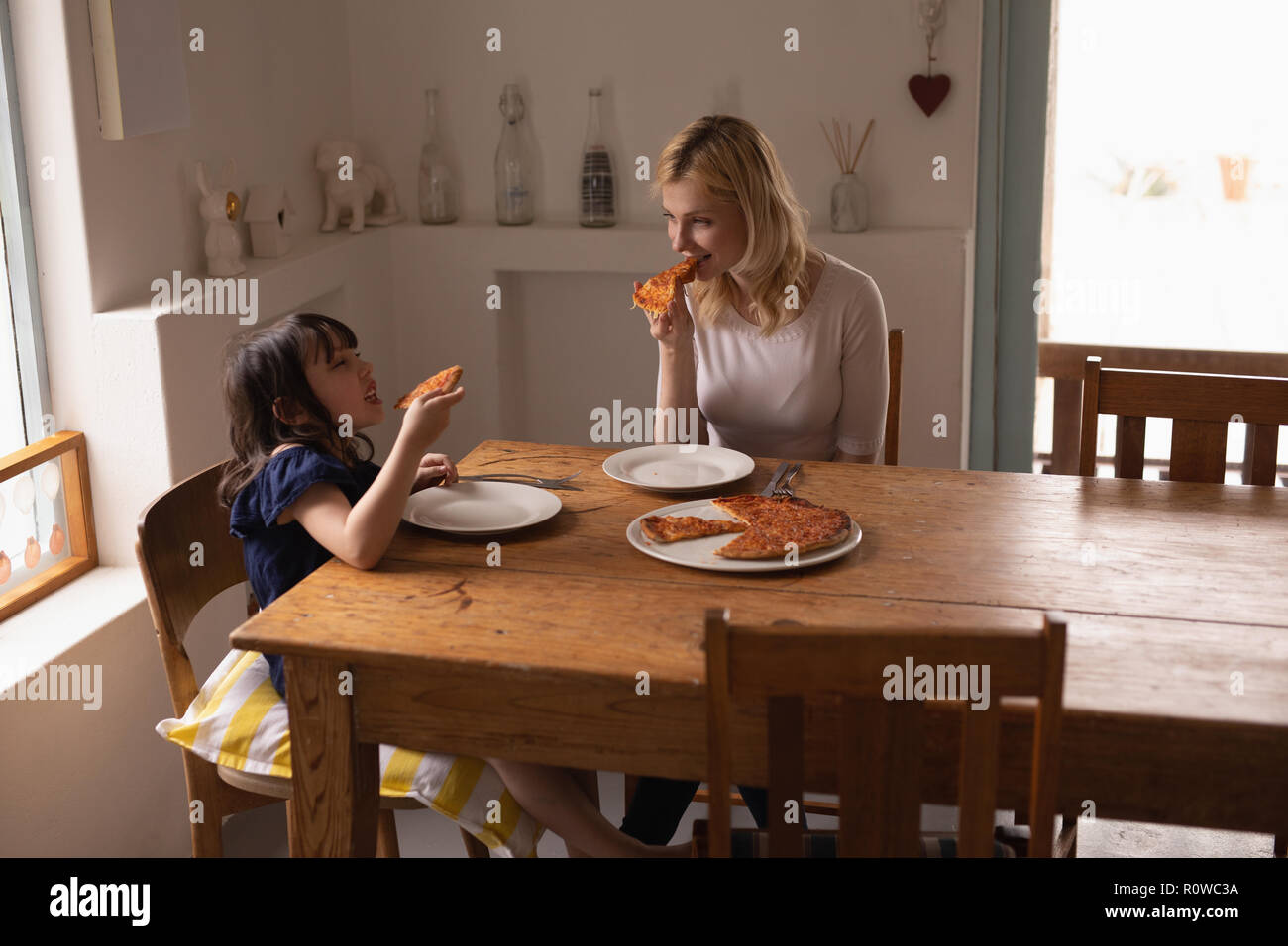 Mère et fille d'avoir de la nourriture sur table à manger Banque D'Images