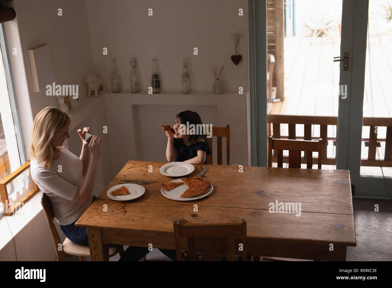 Mère en cliquant sur la photo de sa fille tout en ayant l'alimentation Banque D'Images