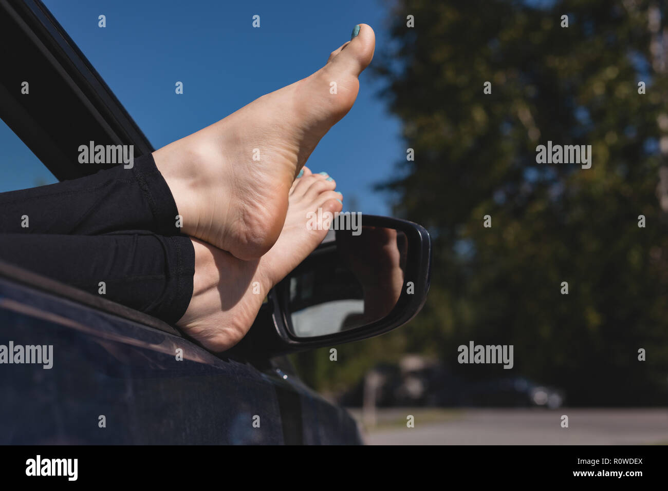 Woman relaxing with feet up dans une voiture Banque D'Images