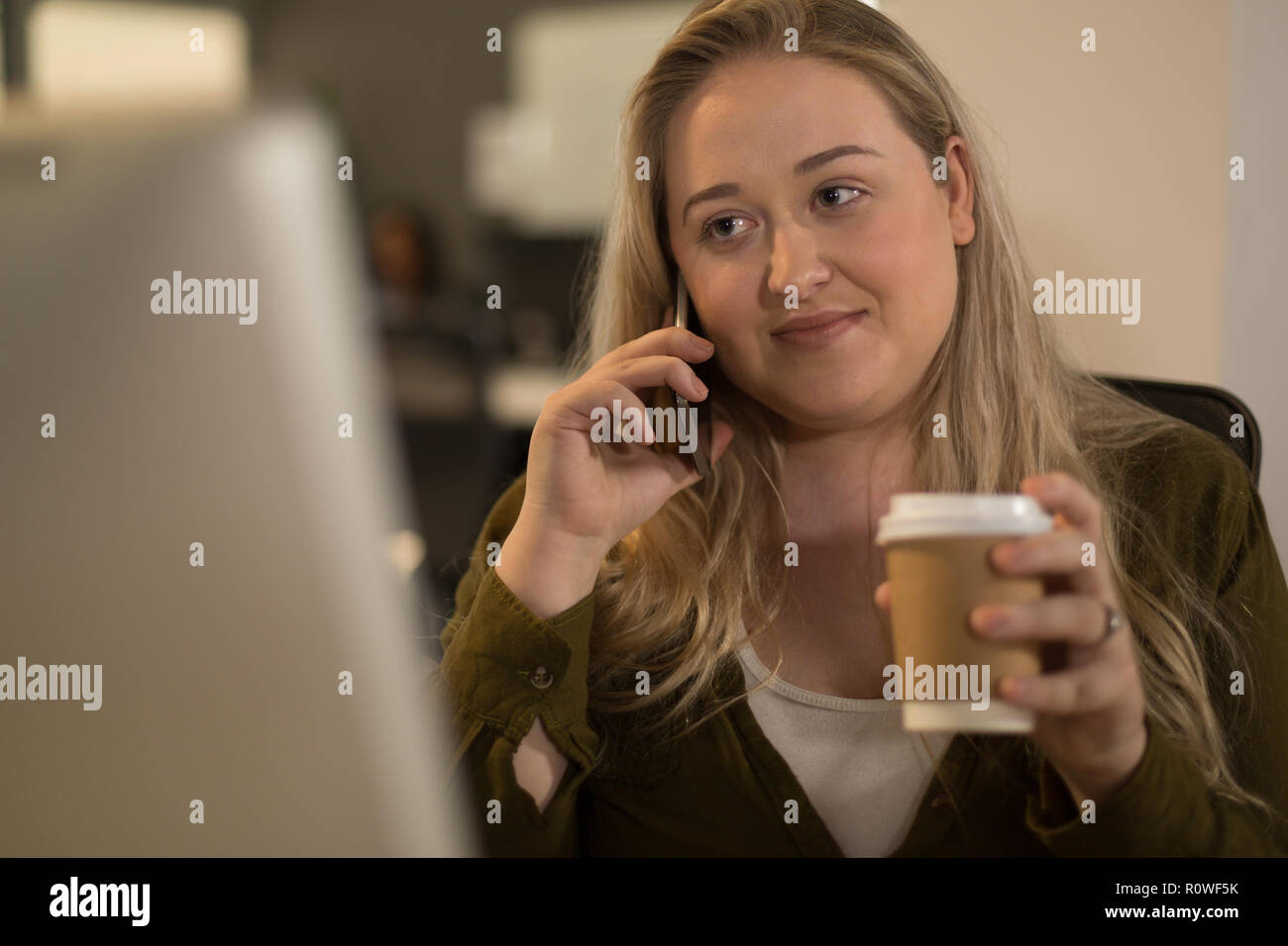 Conseil exécutif talking on mobile phone while having coffee Banque D'Images
