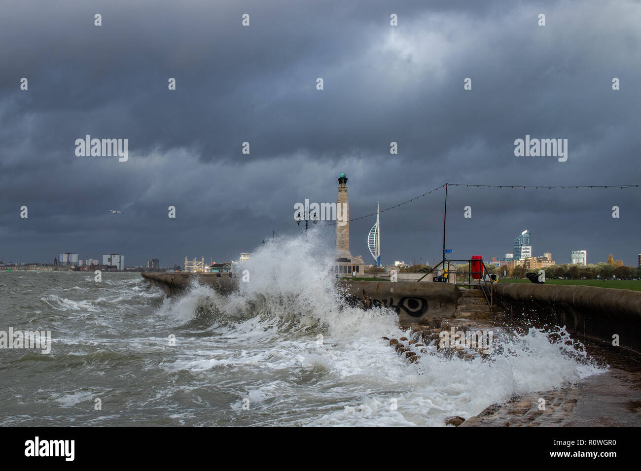 Les défenses de la mer être battu par une tempête en front de mer de Southsea avec de grandes vagues, Naval War Memorial et tour Spinnaker dans l'arrière-plan Banque D'Images