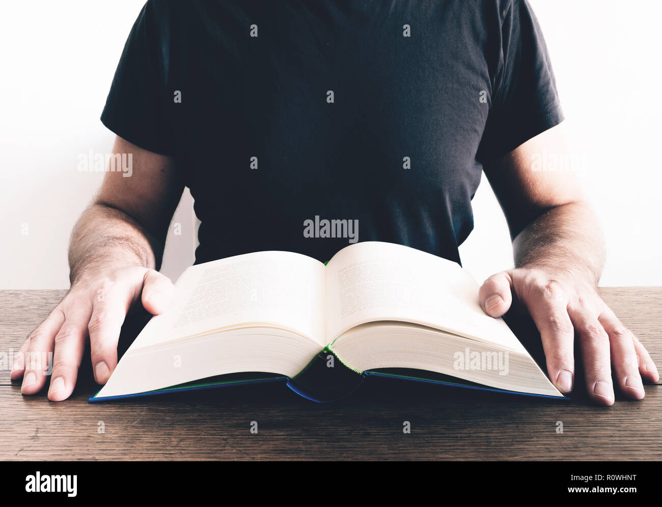 Man reading book at table en bois Banque D'Images
