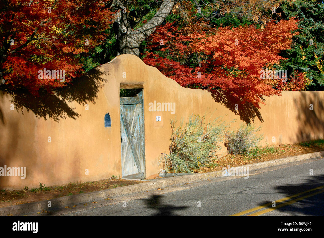 Couleurs d'automne d'oranges occulter ce style adobe passerelle sur Garcia rue Santa Fe, NM, États-Unis Banque D'Images