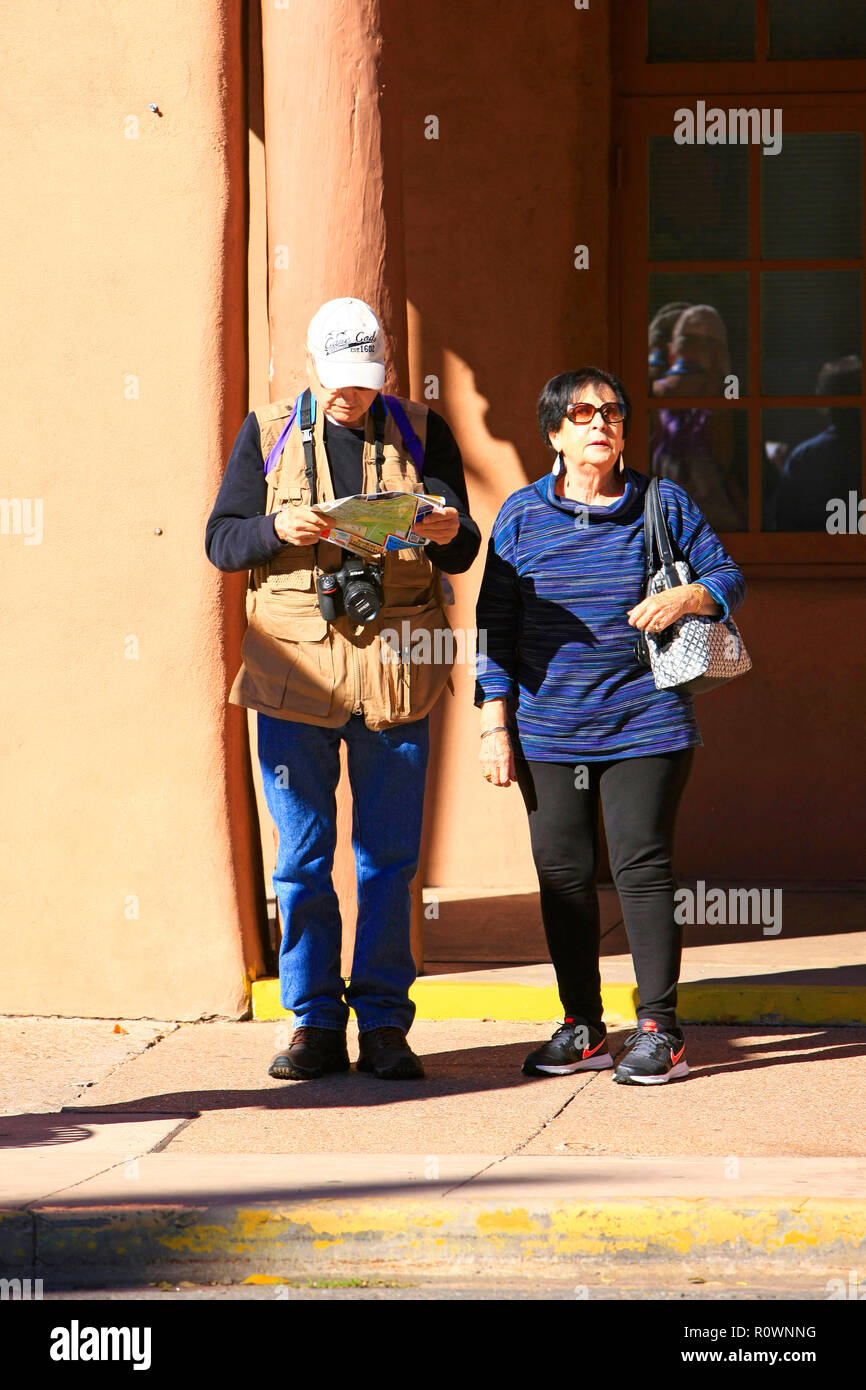 Couple de touristes retraités debout sur un coin de rue à regarder leur site au centre-ville de Santa Fe, Nouveau Mexique, USA Banque D'Images