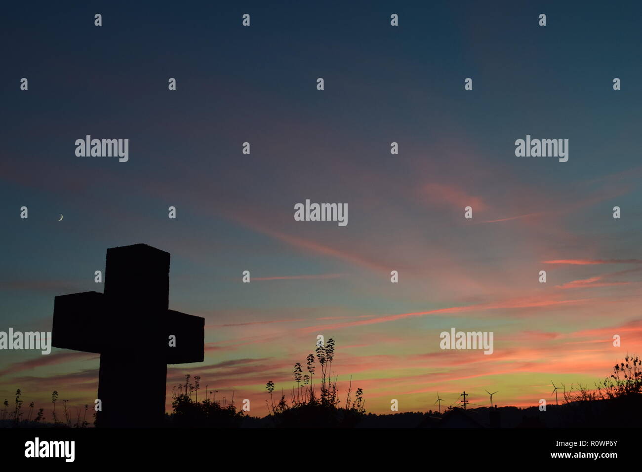 Chronologie de la soirée ciel crépuscule vu de derrière une croix en pierre de sable sculpture au cours de la coucher du soleil soleil dans le cimetière civil Reimsbach, Centre, Banque D'Images