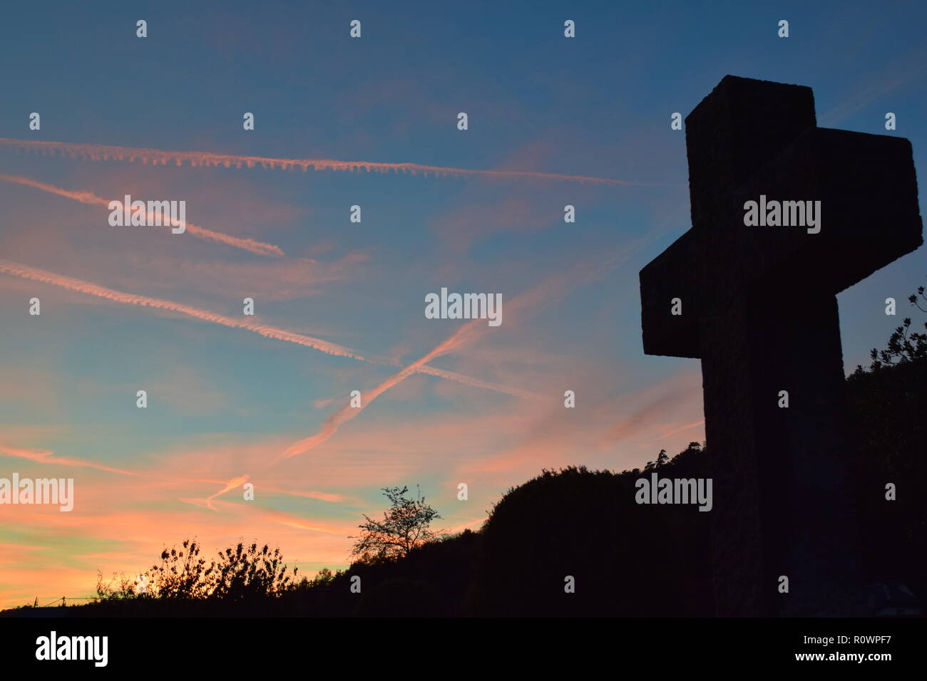 Chronologie de la soirée ciel crépuscule vu de derrière une croix en pierre de sable sculpture au cours de la coucher du soleil soleil dans le cimetière civil Reimsbach, Centre, Banque D'Images