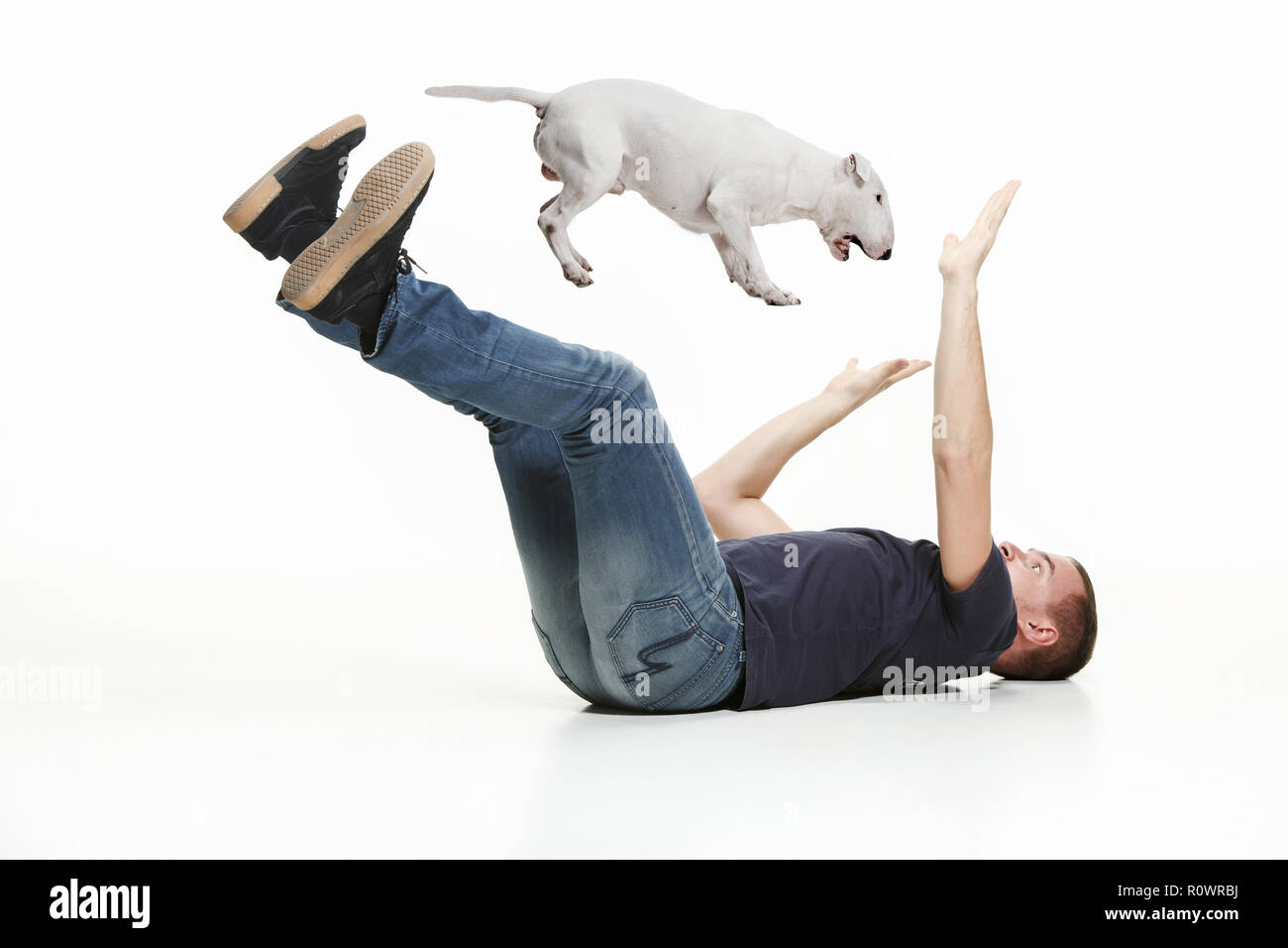 Portrait psychologique de peur l'homme et son chien, le concept d'amitié et de soins de l'homme et l'animal. Chien de type bull-terrier blanc sur fond de studio Banque D'Images