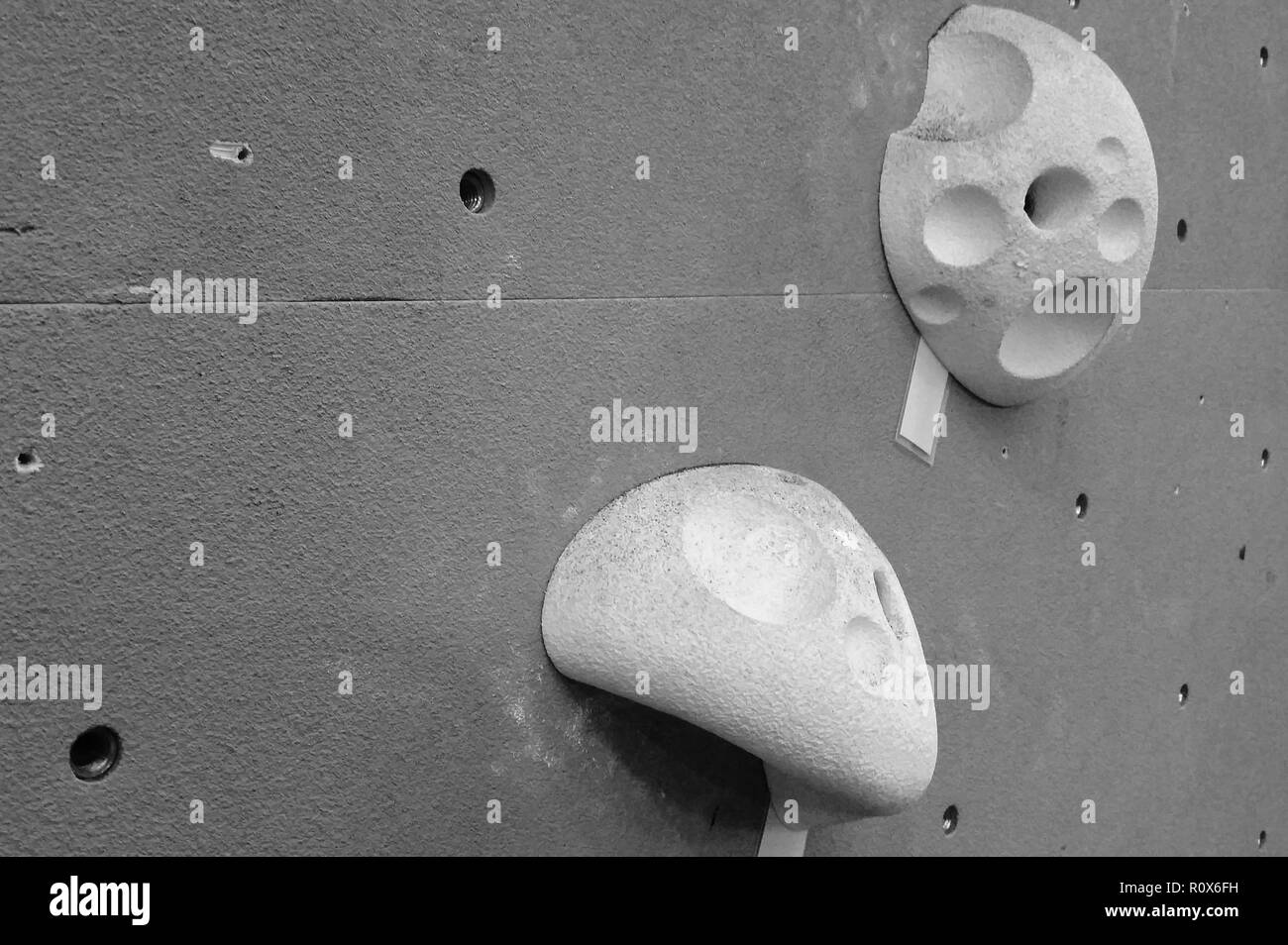 Pichet blanc deux escalade détient contre un mur gris Banque D'Images