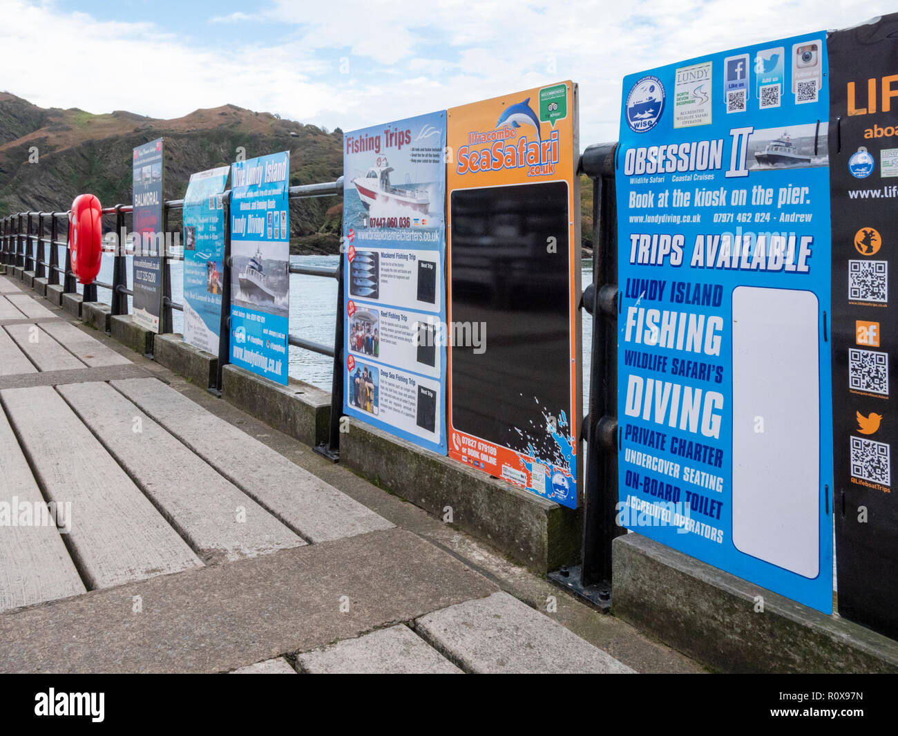 Des excursions touristiques et d'excursion en bateau au port d'affiches publicitaires Ilfracombe Devon UK sur un automne humide hors saison jour o Banque D'Images