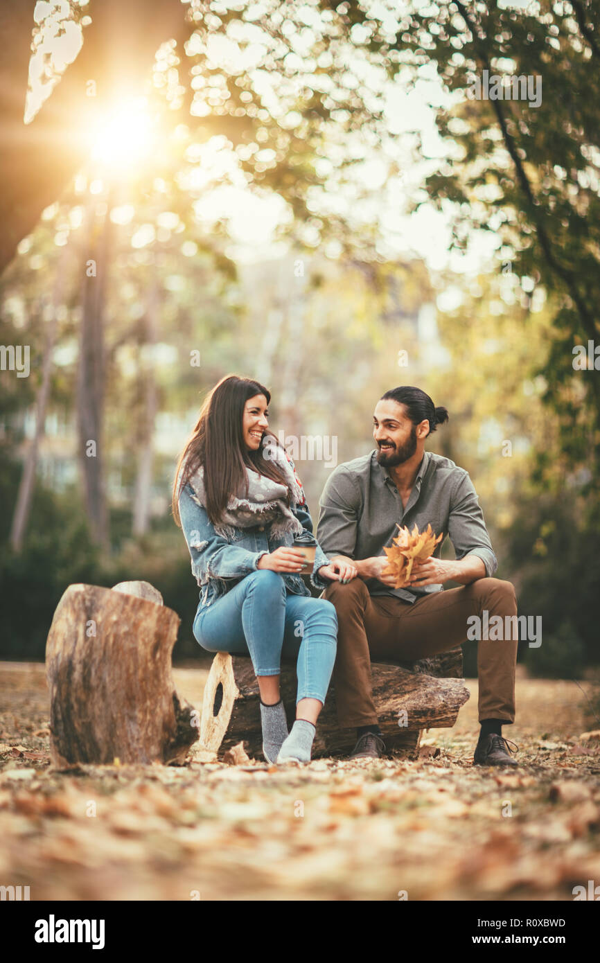 Beautiful smiling couple enjoying sunny city park de couleurs d'automne à l'autre. Ils ont du plaisir avec des feuilles jaunes. Banque D'Images