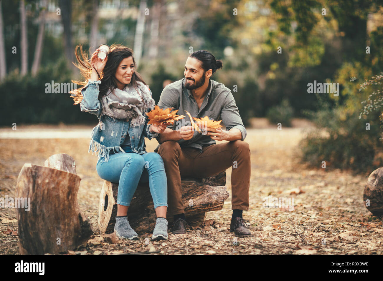 Beautiful smiling couple enjoying sunny city park de couleurs d'automne à l'autre. Ils ont du plaisir avec des feuilles jaunes. Banque D'Images