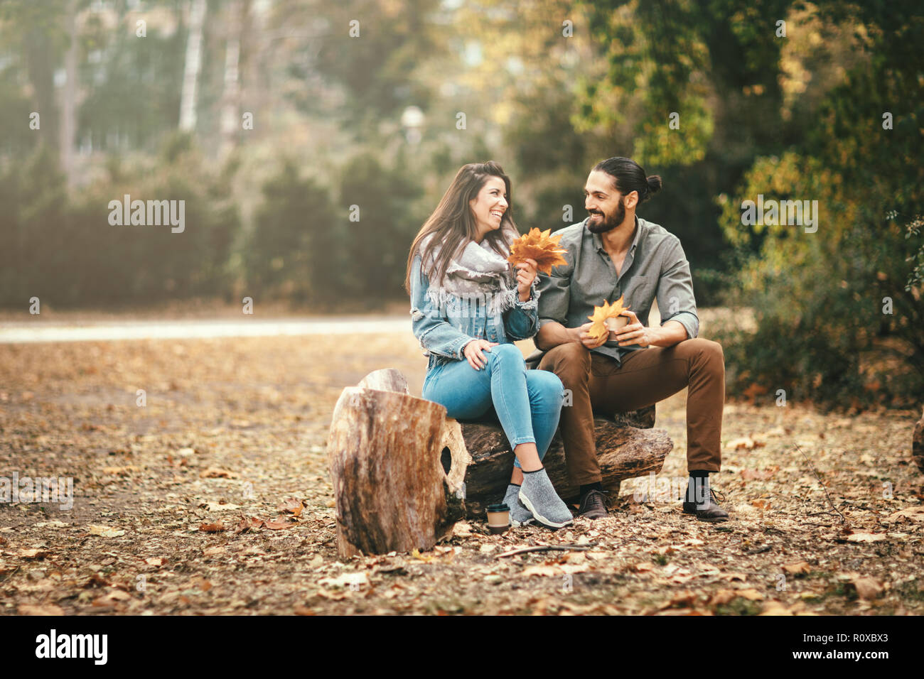 Beautiful smiling couple enjoying sunny city park de couleurs d'automne à l'autre. Ils ont du plaisir avec des feuilles jaunes. Banque D'Images