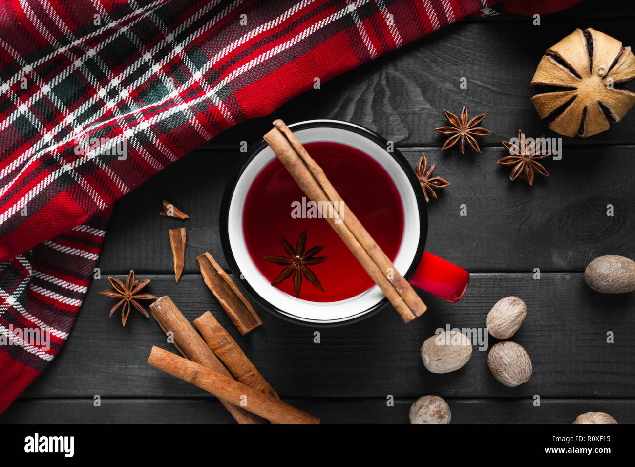 Vin chaud de Noël aux épices dans la tasse rouge sur fond de bois. Banque D'Images