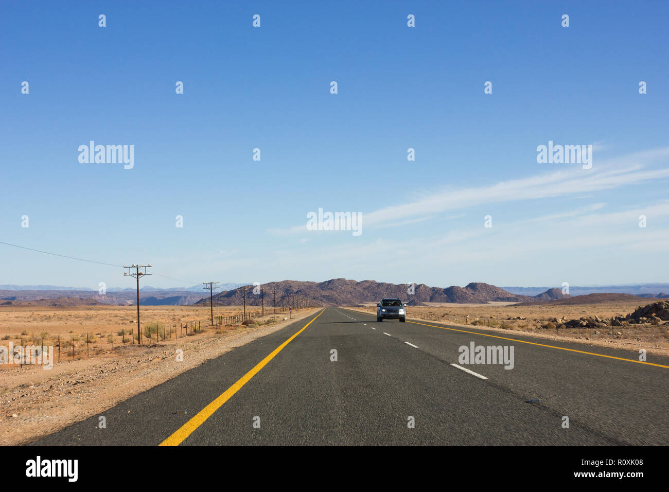 Voiture de tourisme sur route nationale goudronnée en sec et aride de l'Afrique sur la cape du paysage route Namibie Banque D'Images