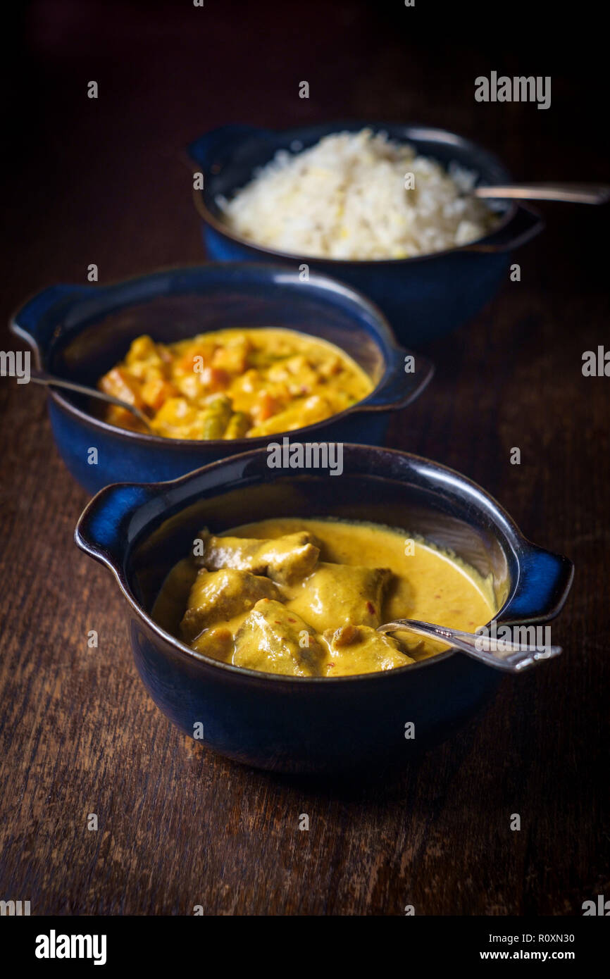 La nourriture indienne crémeux Rogan Josh d'Agneau Korma de légumes et riz basmati blanc avec des bols en Banque D'Images