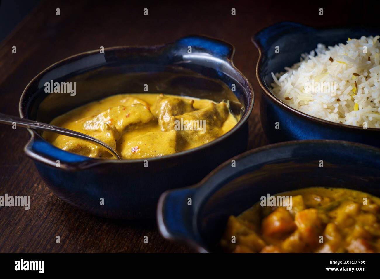 La nourriture indienne crémeux Rogan Josh d'Agneau Korma de légumes et riz basmati blanc avec des bols en Banque D'Images