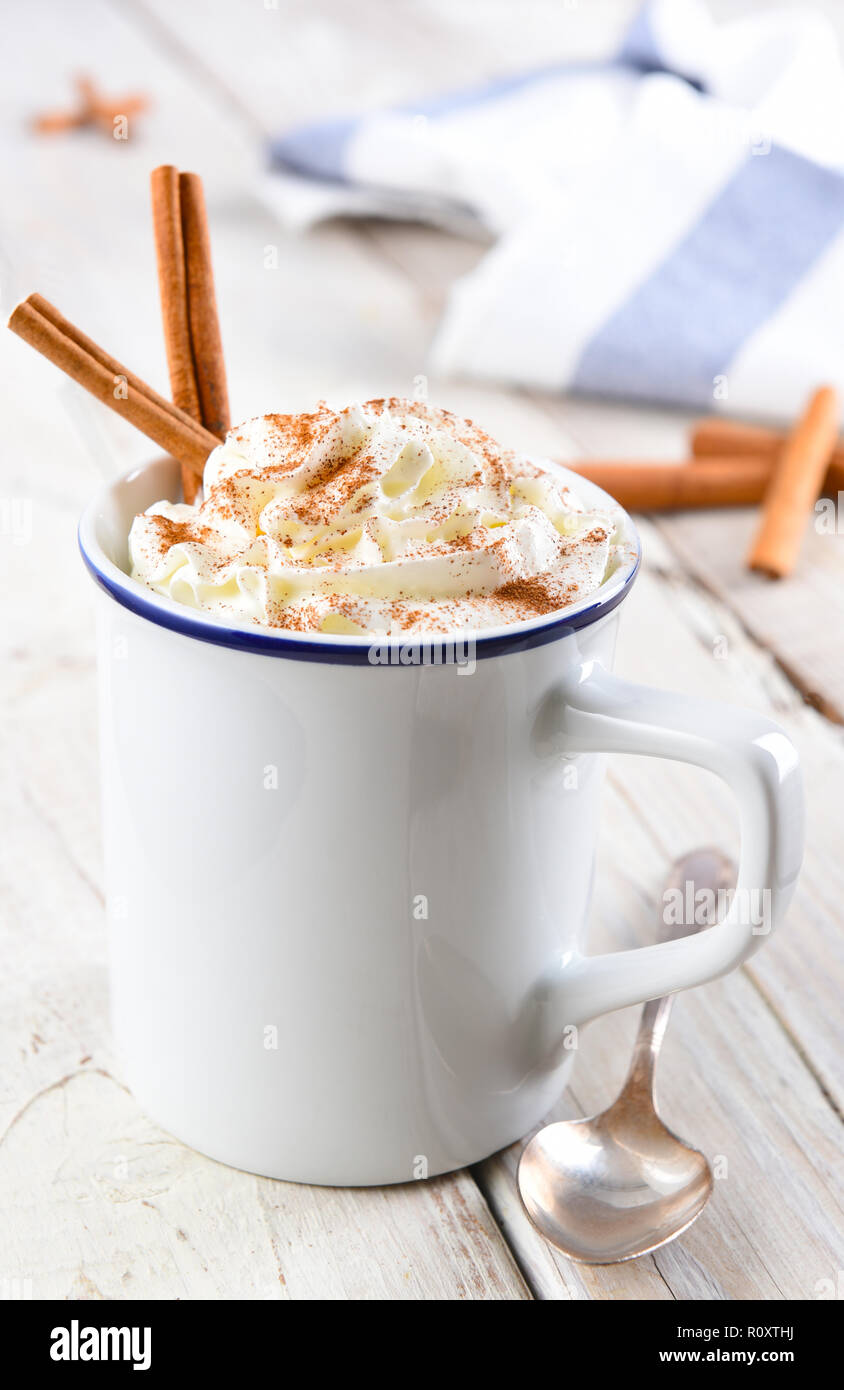 Chocolat chaud en blanc mug avec des bâtons de cannelle. Format vertical avec une faible profondeur de champ. Banque D'Images