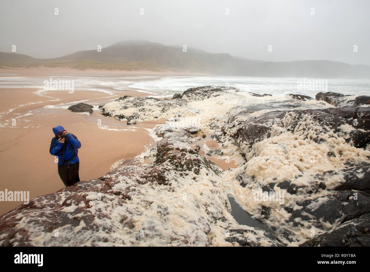 Les randonneurs de spume ou écume de mer sur la plage de Sandwood Bay lors de coups de vent, Sutherland, Scotland, UK. Banque D'Images