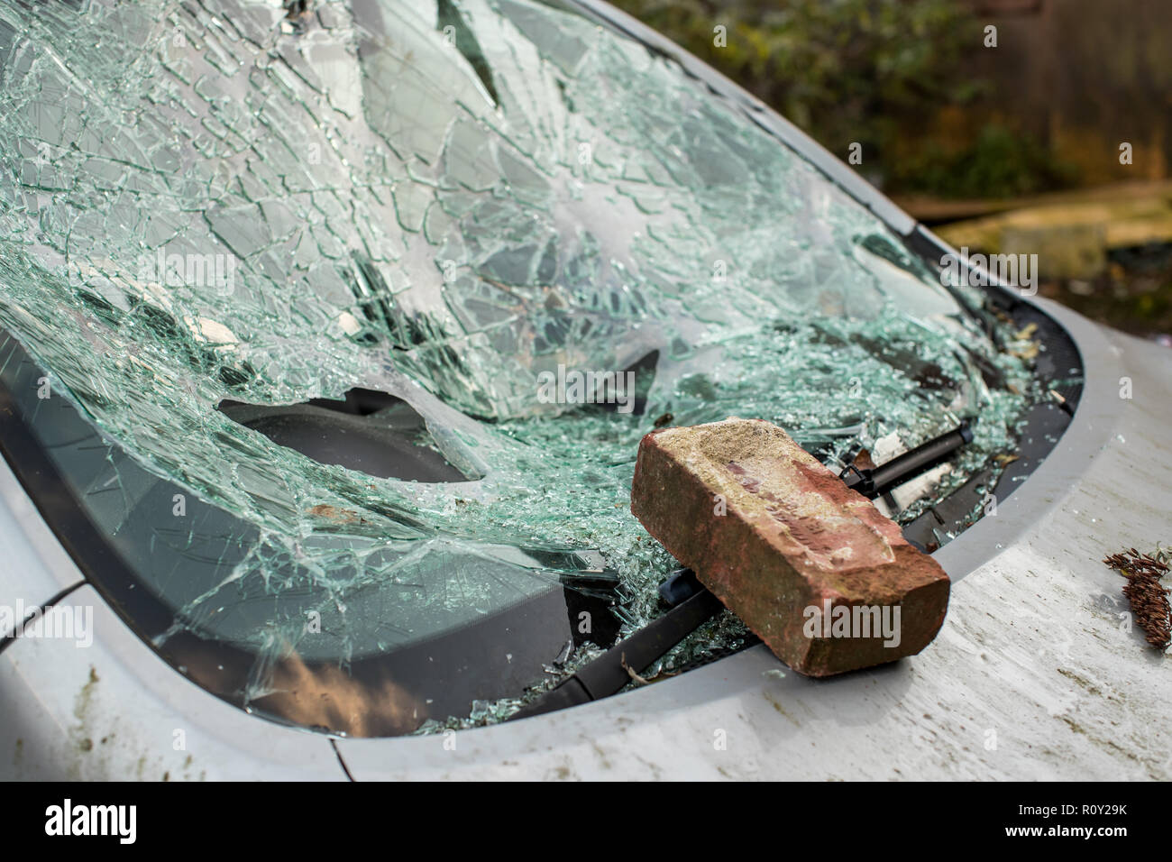 La brique se trouve sur le pare-brise fracassé d'une voiture avec des éclats de verre partout. La voiture a été cambriolé et volés. Car le crime est un problème dans United Kin Banque D'Images
