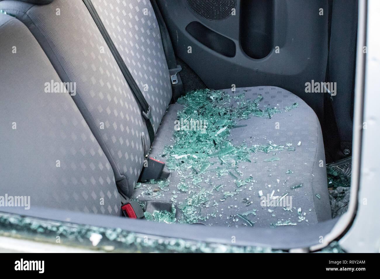 Le siège arrière d'une voiture vandalisée de tessons de verre brisé couvrant le siège. La voiture a été cambriolé et volés. Banque D'Images