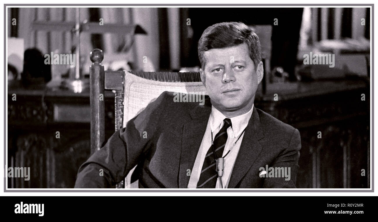 Le président John F. Kennedy JFK reportage candide informelle droit dans la Maison Blanche, assis dans son fauteuil à bascule portant un micro pendant le tournage d'une interview télévisée, DÉCEMBRE 1962 Banque D'Images