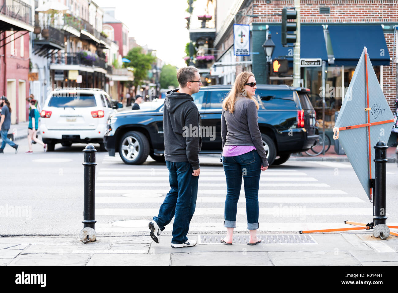 New Orleans, USA - 22 Avril 2018 : vieille ville Decatur Street en Louisiane célèbre ville, deux personnes en attente à cross road à coucher soleil soir Banque D'Images