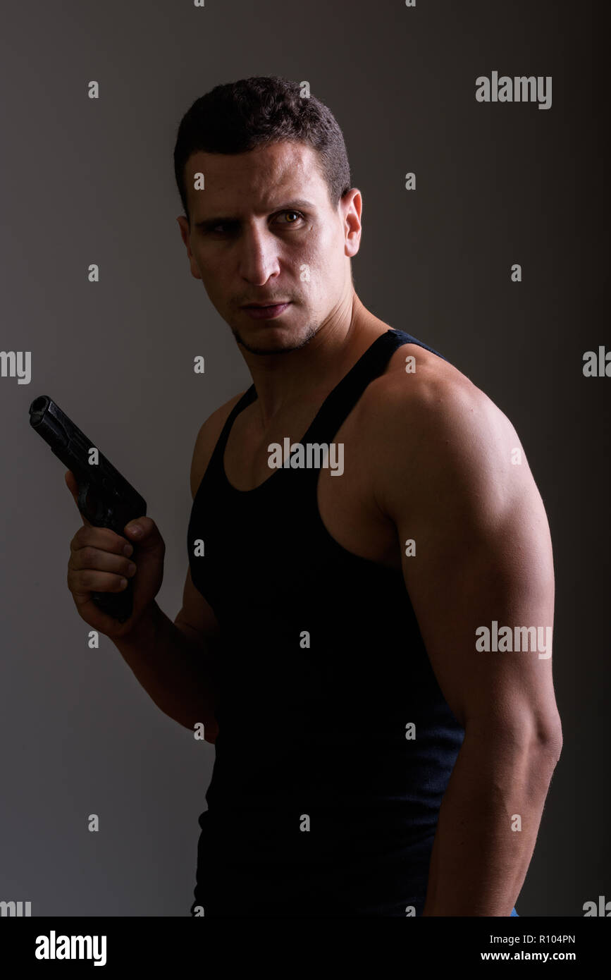 Young man holding persan musculaire et des armes à feu à la ba Banque D'Images