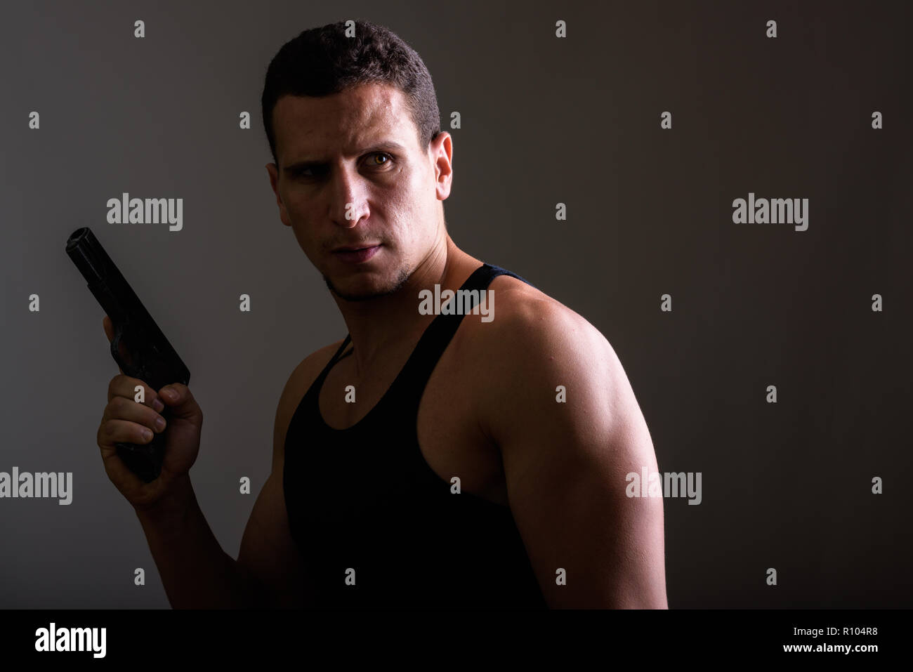 Portrait of young man holding gun persan musculaire tout en fine Banque D'Images