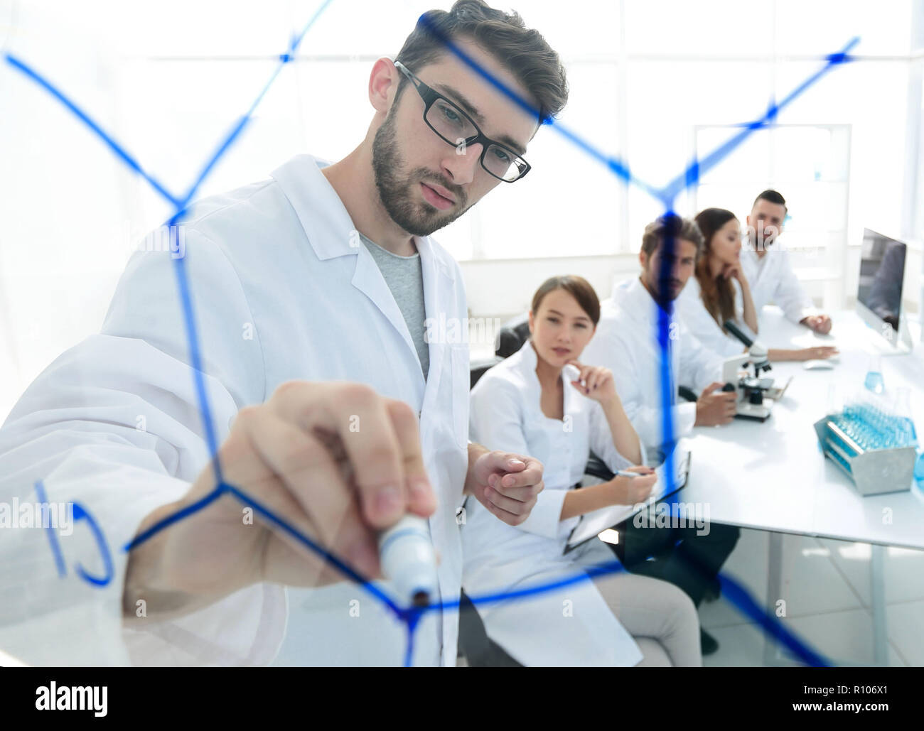 De derrière la vitre.scientist écrit un marqueur sur un bord de verre. Banque D'Images