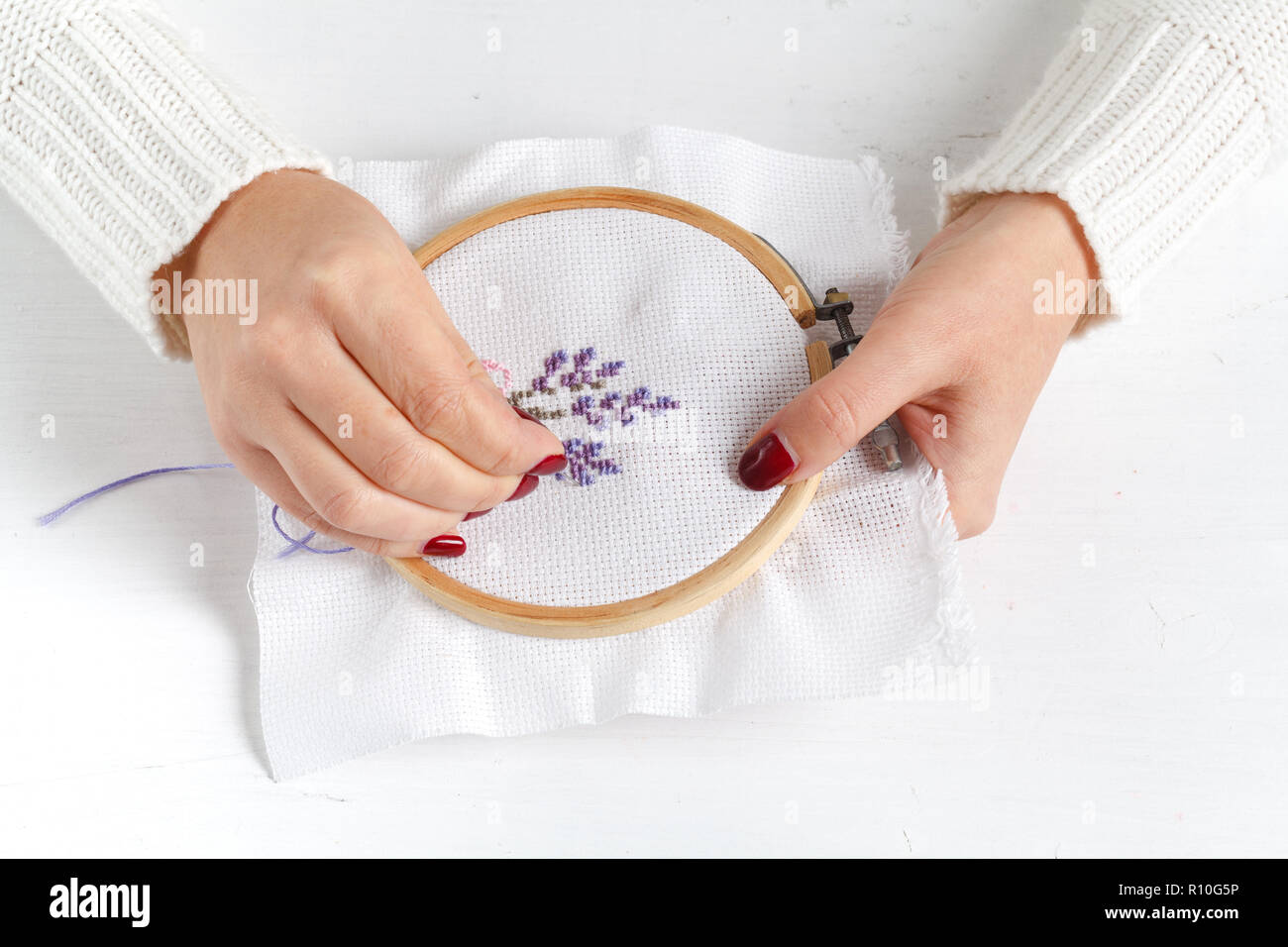 Les mains de la jeune fille sur la broderie de travail Banque D'Images