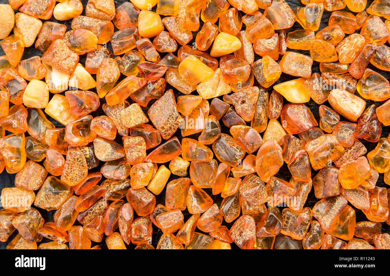 Contexte tout entier recouvert de morceaux d'ambre orange. La région de la Baltique est le plus grand gisement connu de l'ambre, l'ambre baltique appelé ou su Banque D'Images