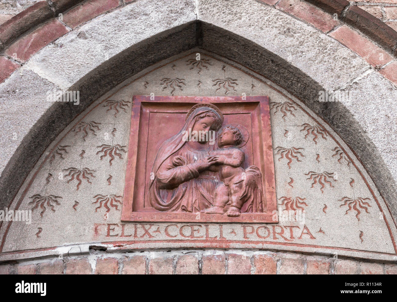 Sculpture de Marie et l'enfant Jésus au-dessus de l'entrée d'une église italienne. La statue est dans un bas-relief. Idéal pour des événements, des concepts et de milieux différents. Banque D'Images