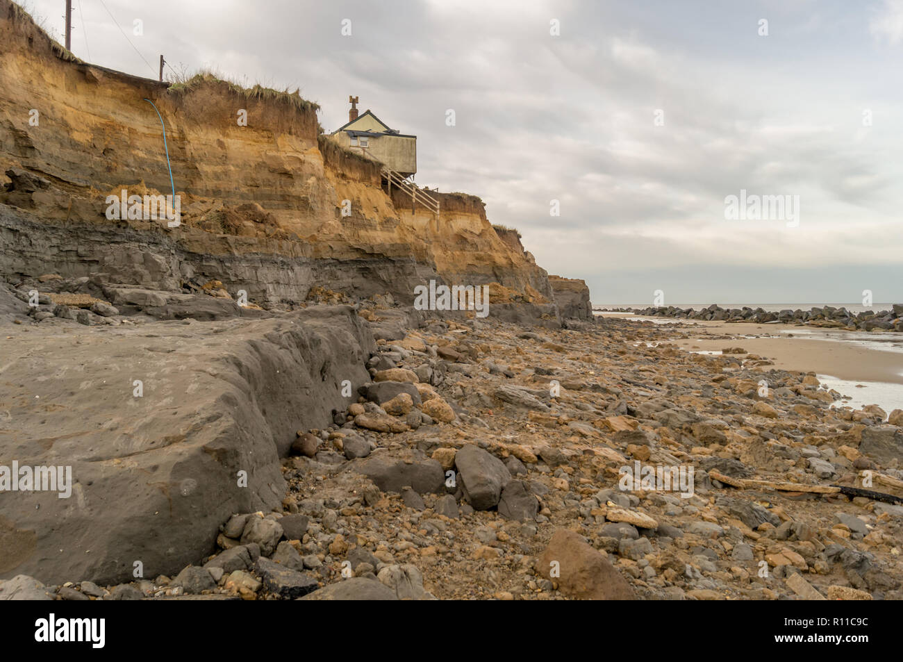 Chambre le bord de la falaise lavés par la mer, l'érosion côtière, le réchauffement climatique, la hausse du niveau de la mer, Happisburgh Norfolk, UK Banque D'Images