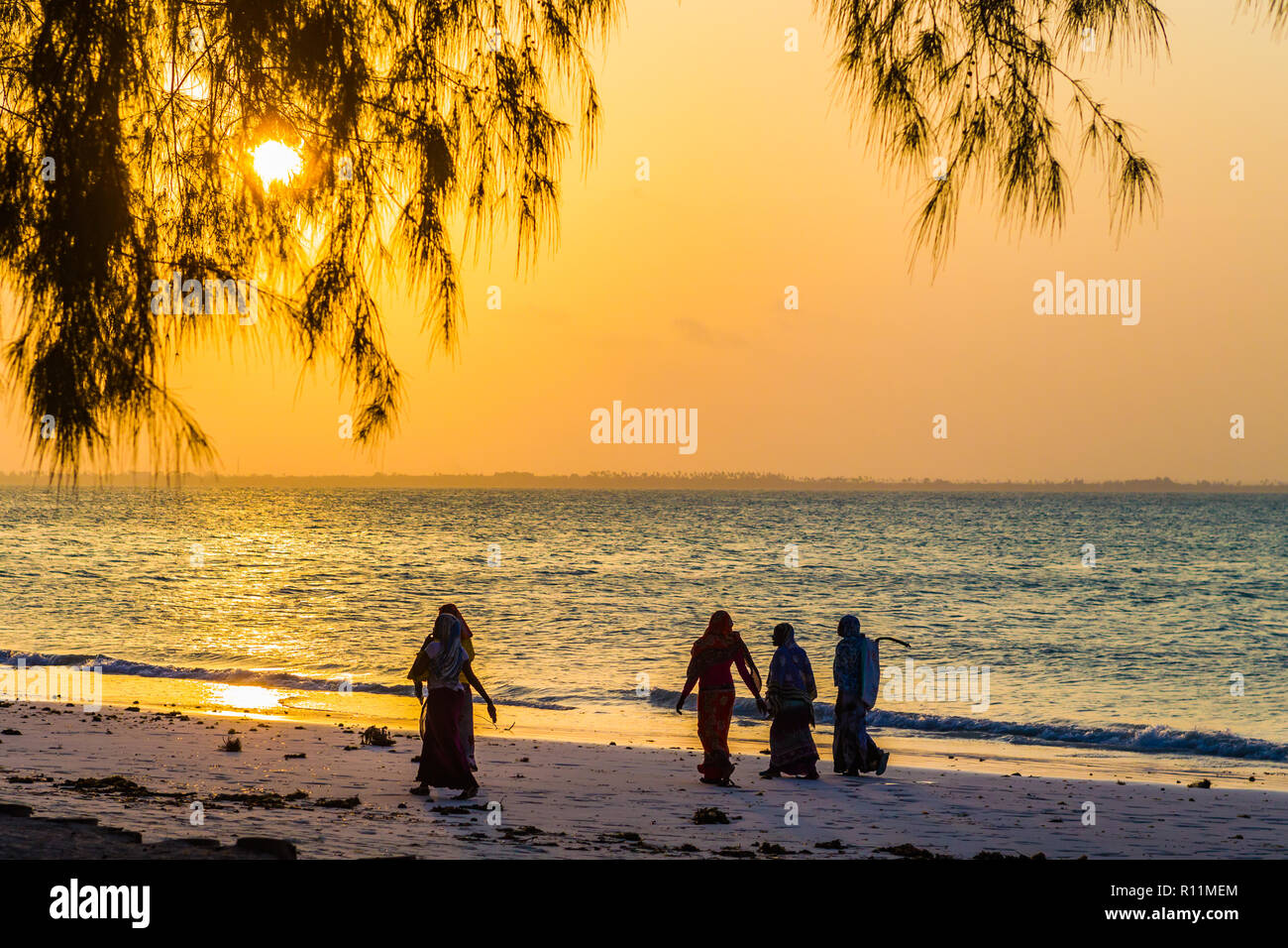Silhouettes de femmes au coucher du soleil. Village de Paje, Zanzibar, Tanzanie Banque D'Images