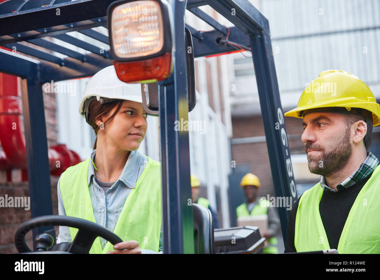 La femme comme conducteur de chariot élévateur et collègue travailler ensemble dans un transitaire Banque D'Images
