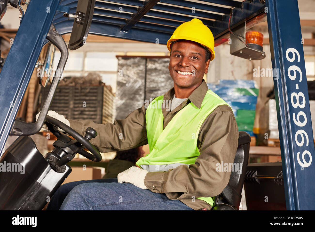 L'homme africain comme un conducteur de chariot élévateur dans la formation dans le centre logistique Banque D'Images