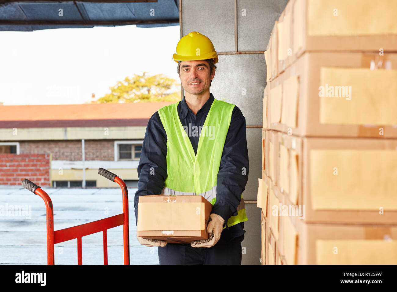 Travailleur de la logistique avec un paquet pour l'expédition dans l'entrepôt dans le commerce en ligne Banque D'Images