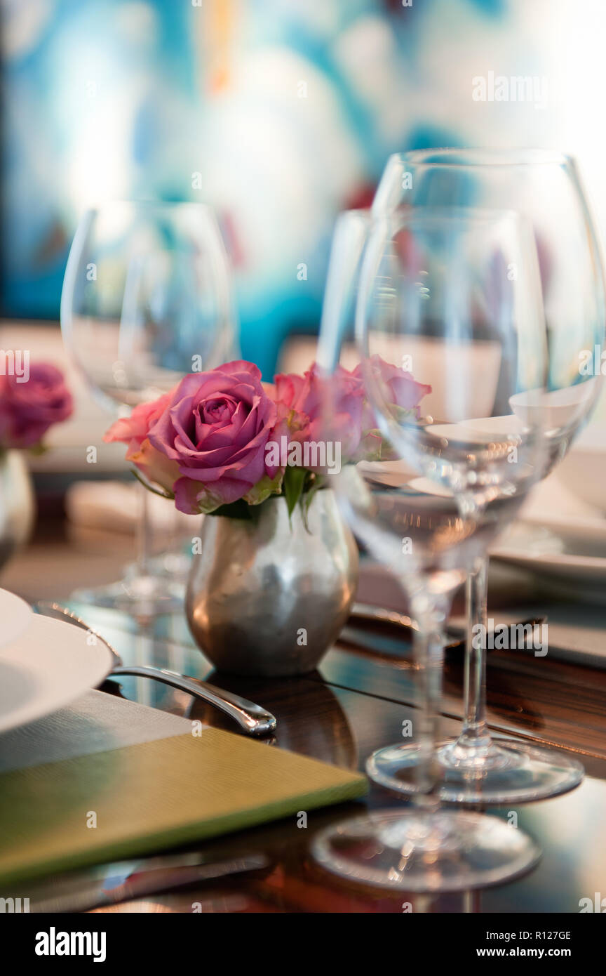 Verres à vin et des roses sur une table à manger Banque D'Images