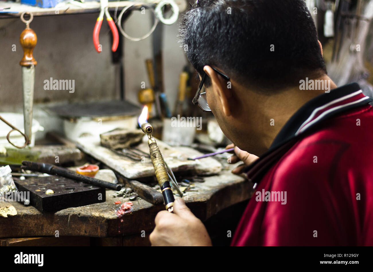 Maître joaillier de souder un ornement dans un atelier de joaillerie. Image du produit mains et close up. Banque D'Images