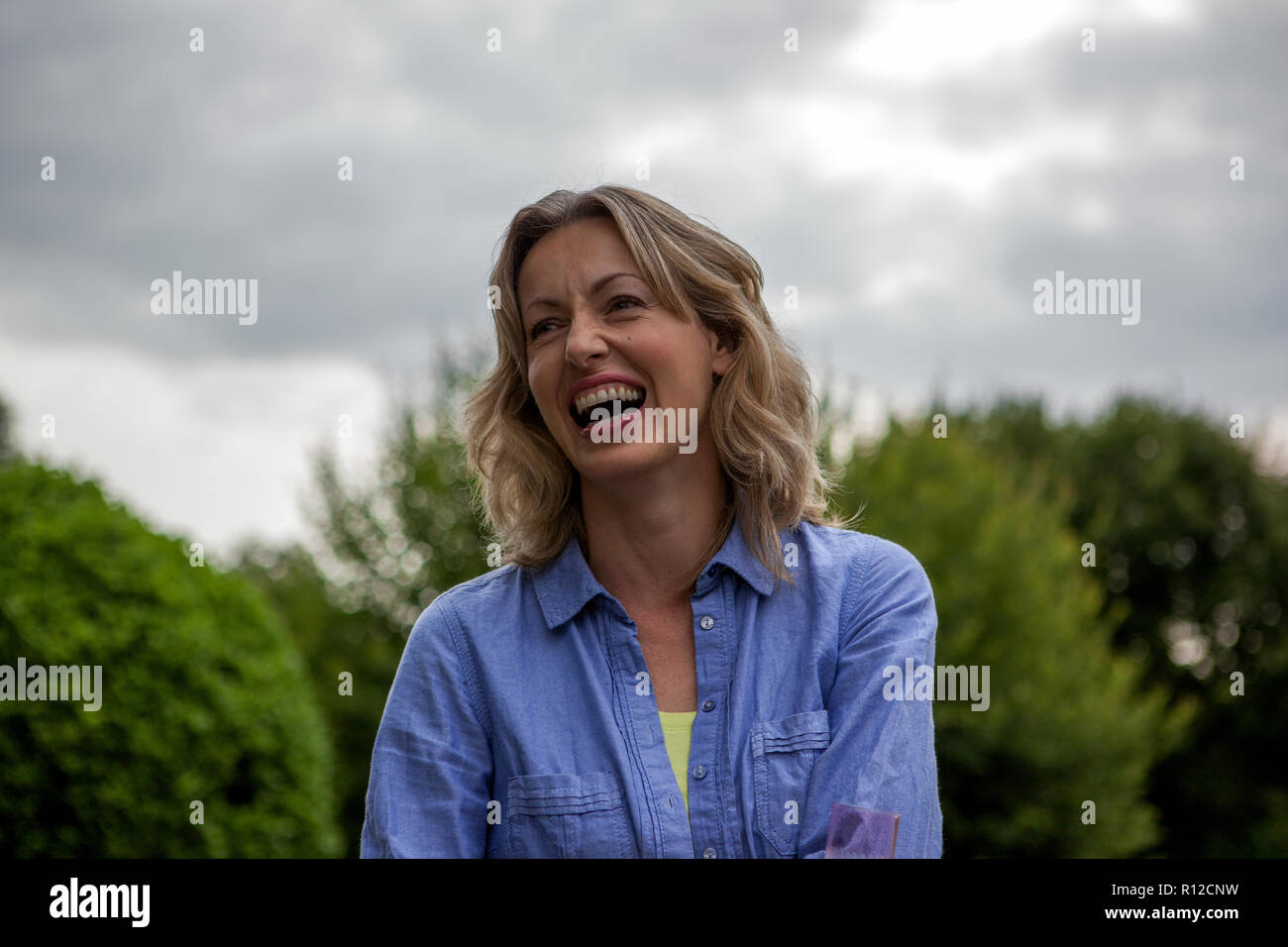 Young woman laughing in garden portrait de la tête et des épaules, Banque D'Images