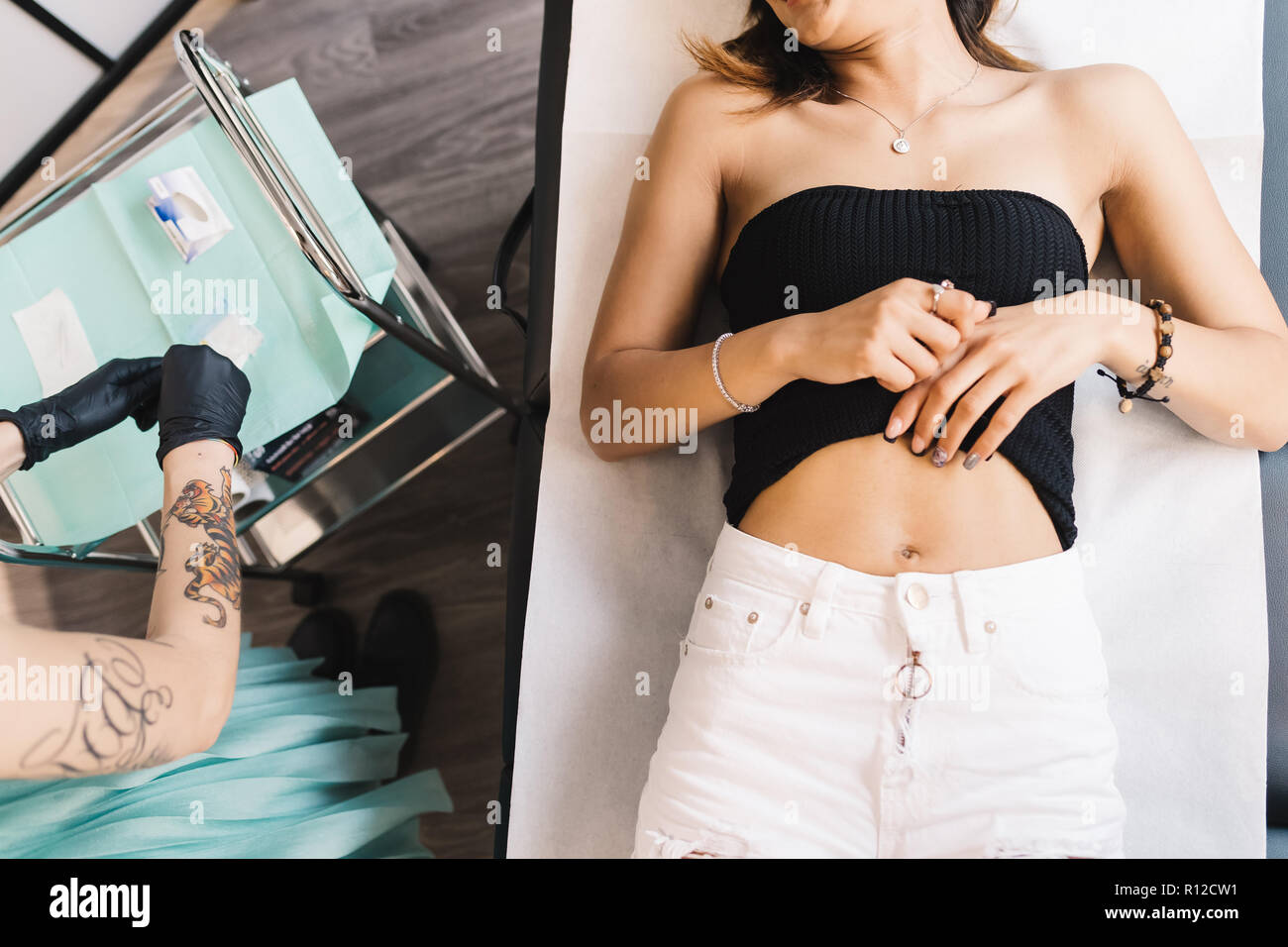 Tatoueur fréquentant au client dans le salon Banque D'Images Tatoueur fréquentant au client dans le salon Banque D'Images