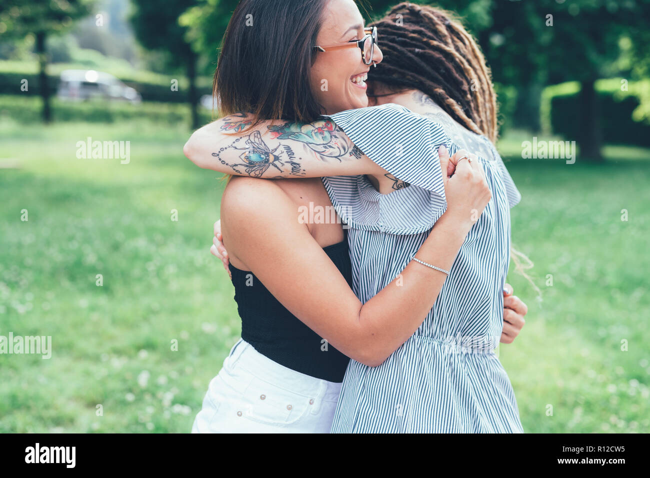 Girlfriends hugging in park Banque D'Images