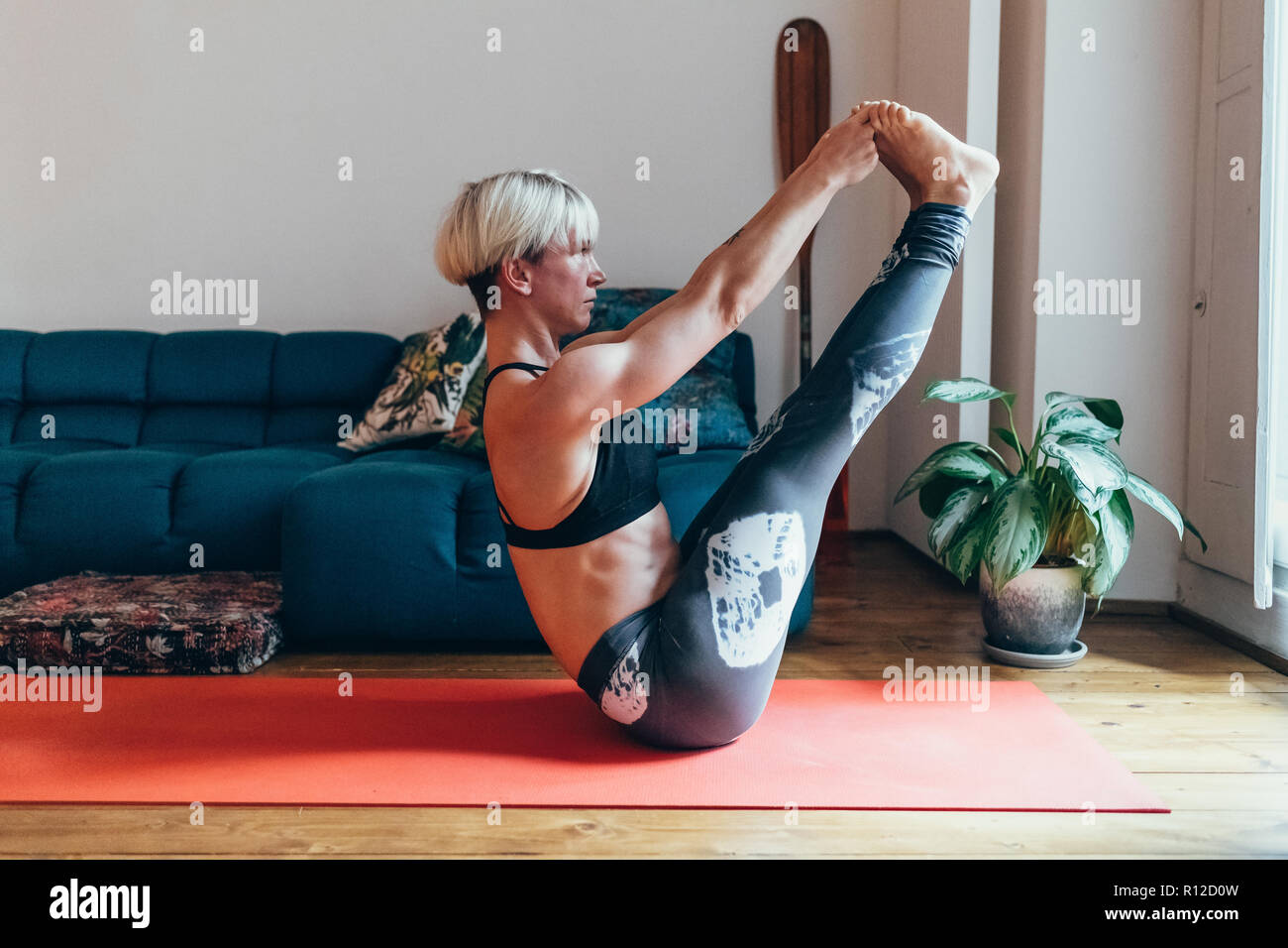 Woman practicing yoga at home Banque D'Images