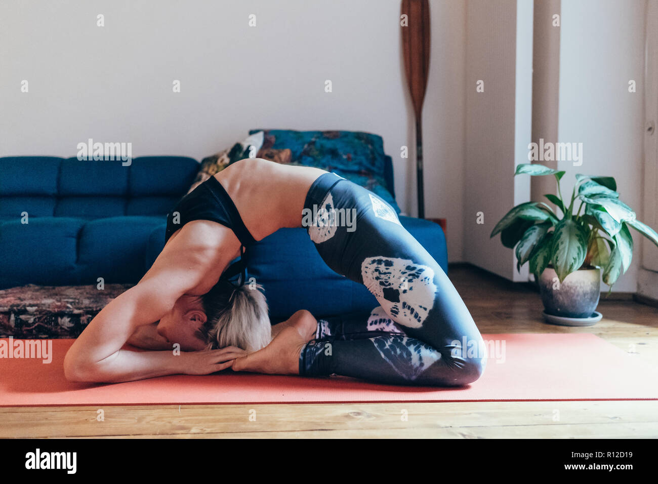 Woman practicing yoga at home Banque D'Images